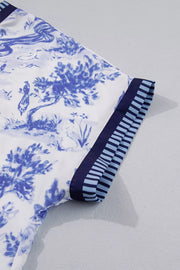 Blouse with blue toile print and striped sleeve accents.