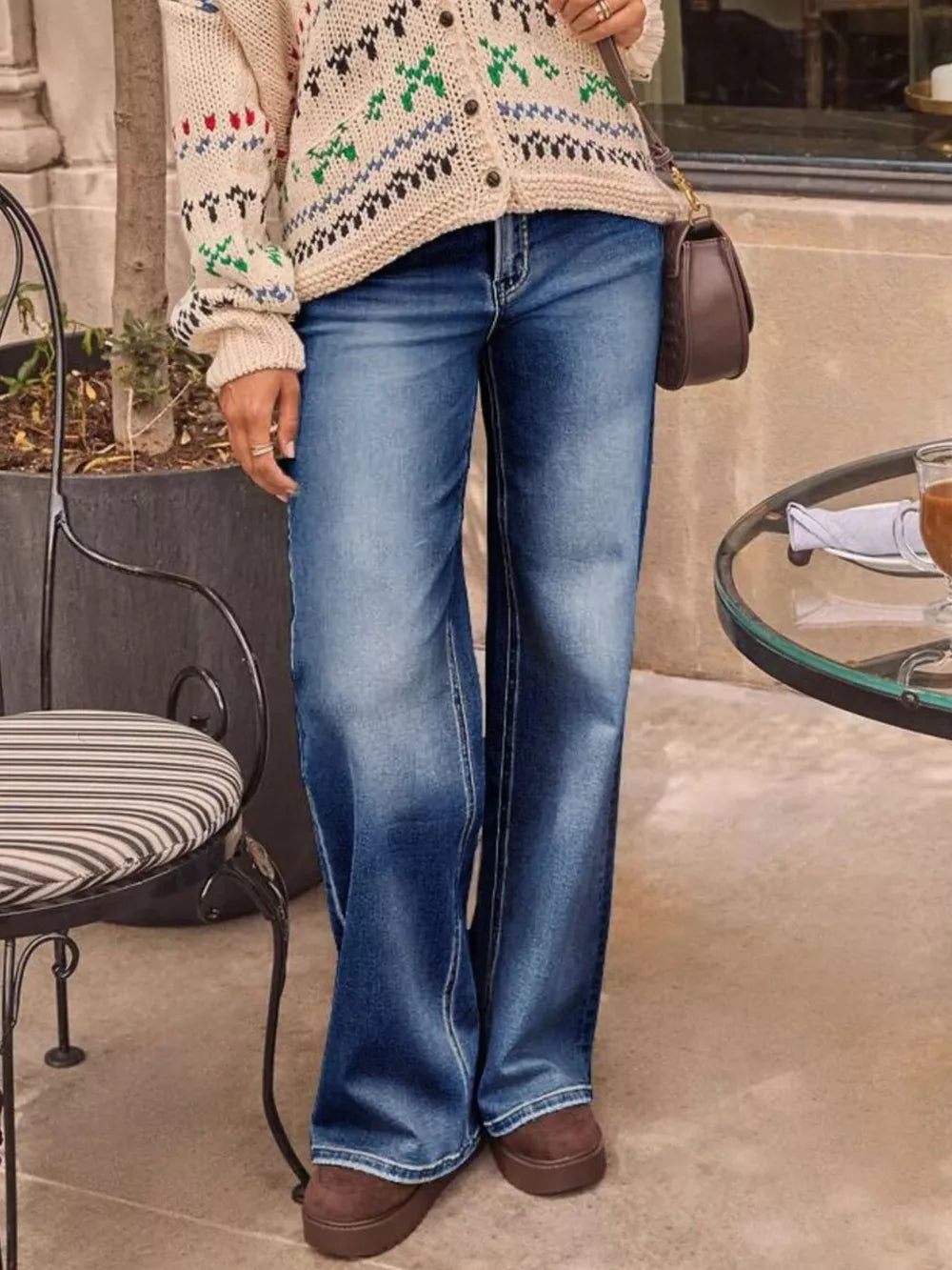 Light blue denim jeans with a high waist and flared leg, detailed with white stitching.