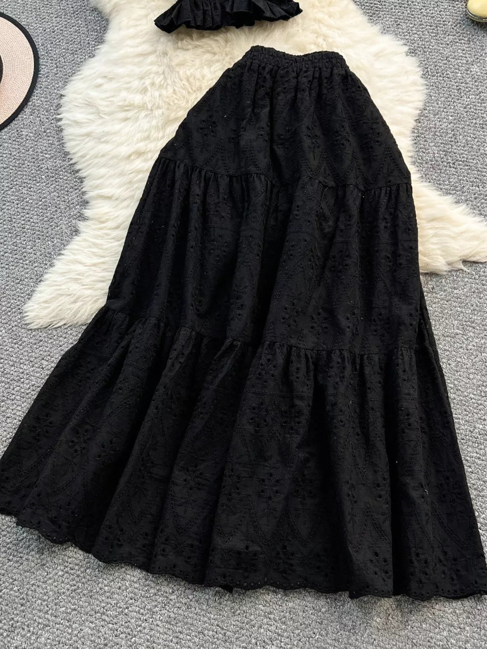 Black eyelet maxi skirt with tiered ruffles and elastic waistband.