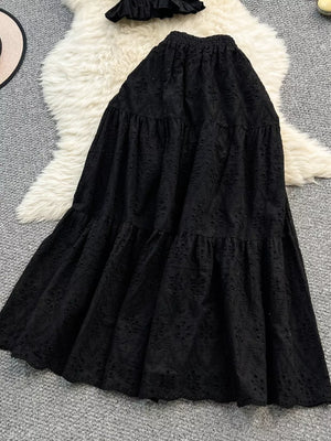 Black eyelet maxi skirt with tiered ruffles and elastic waistband.