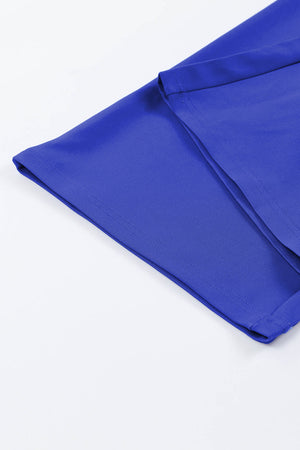 Royal blue jumpsuit with tie waist detail, close-up of fabric and stitching.