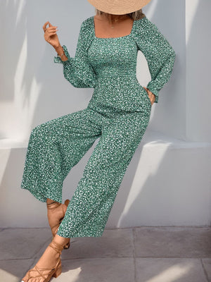Floral jumpsuit with square neck, smocked waist, and wide legs in green.