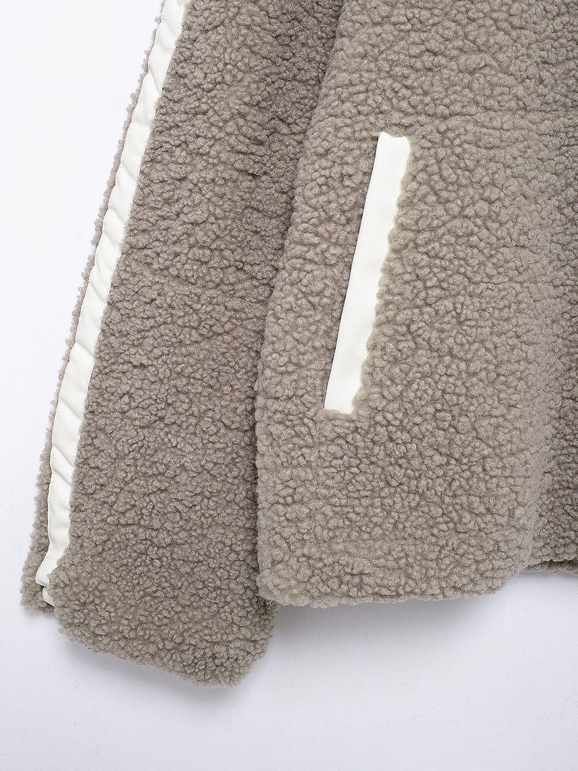 Dust Storm teddy fleece zip-up jacket with white contrast piping and pocket detail.