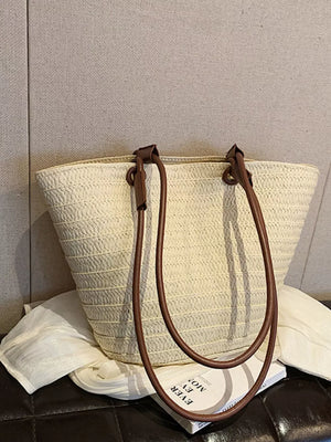 Natural straw woven large shoulder bag in beige with brown leather straps.