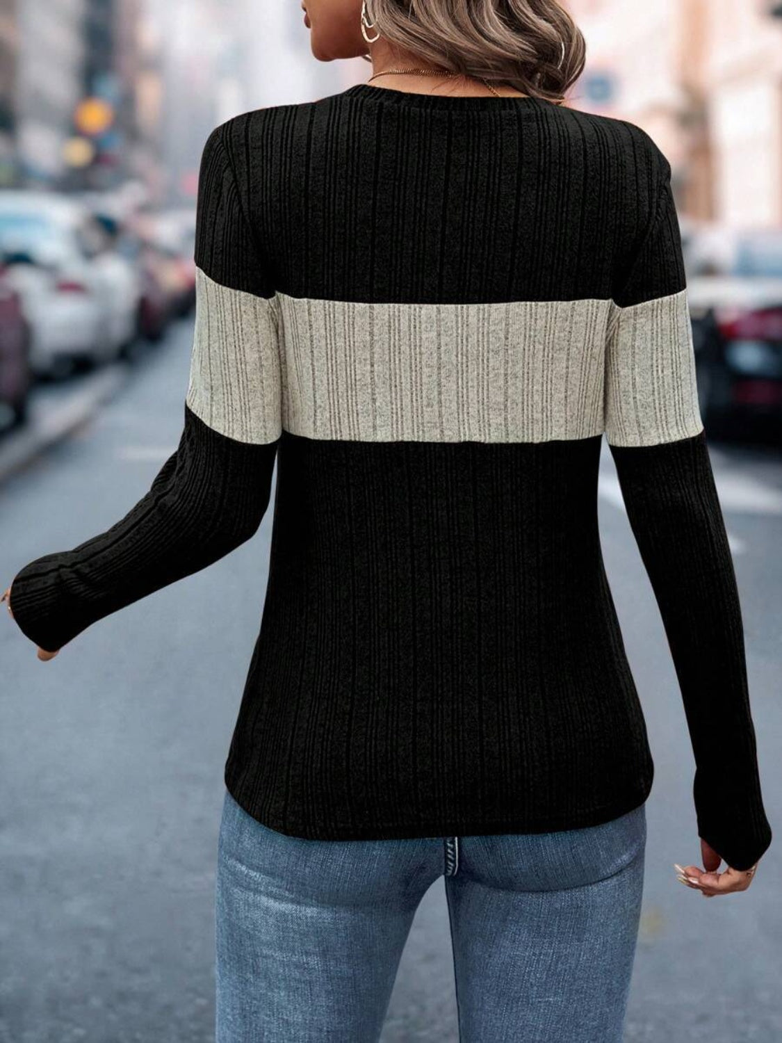 Ribbed crewneck sweater in black and beige colorblock with long sleeves.