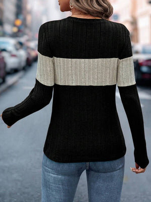 Ribbed crewneck sweater in black and beige colorblock with long sleeves.