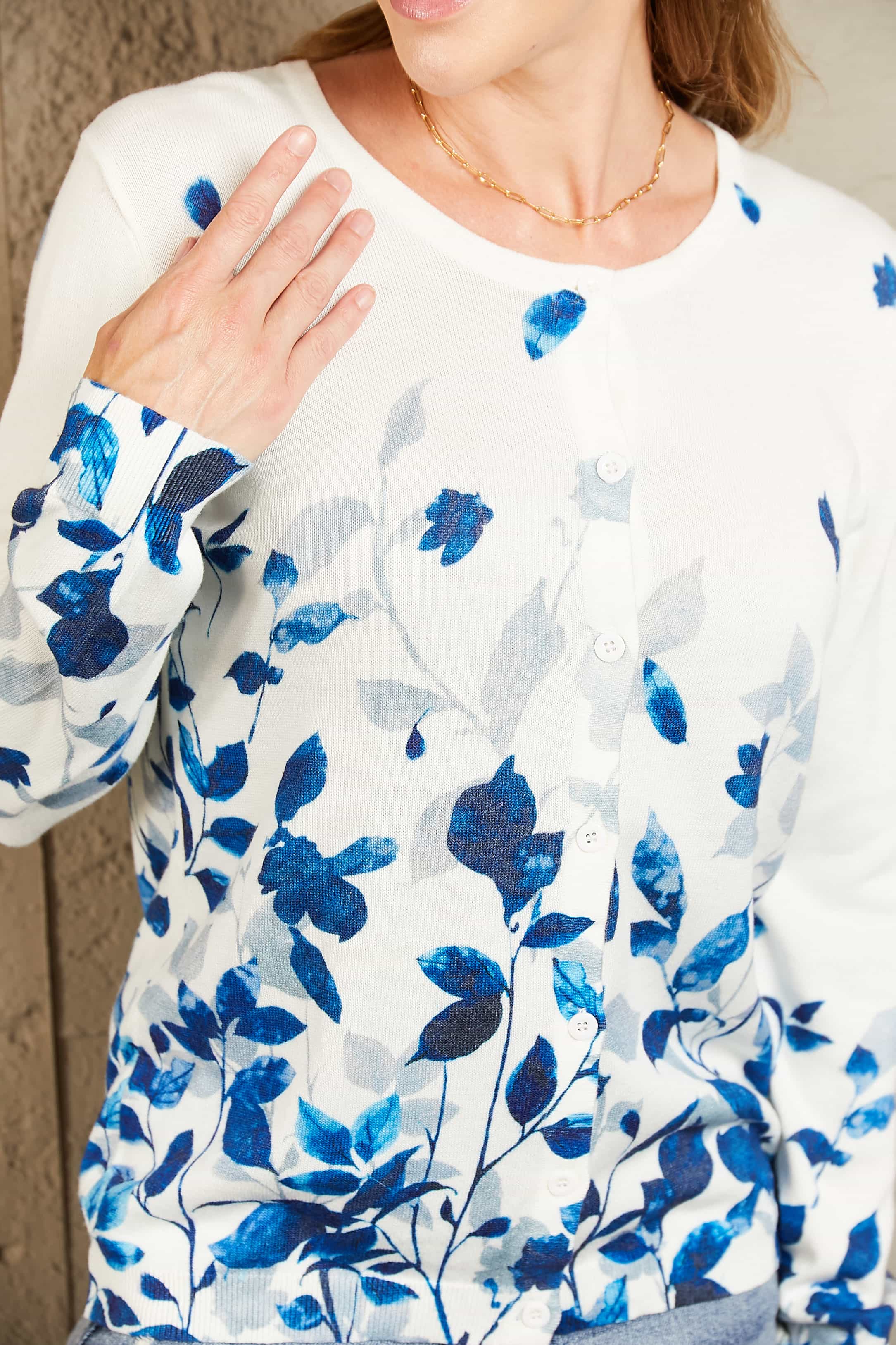 White crewneck cardigan with blue botanical print and button front.