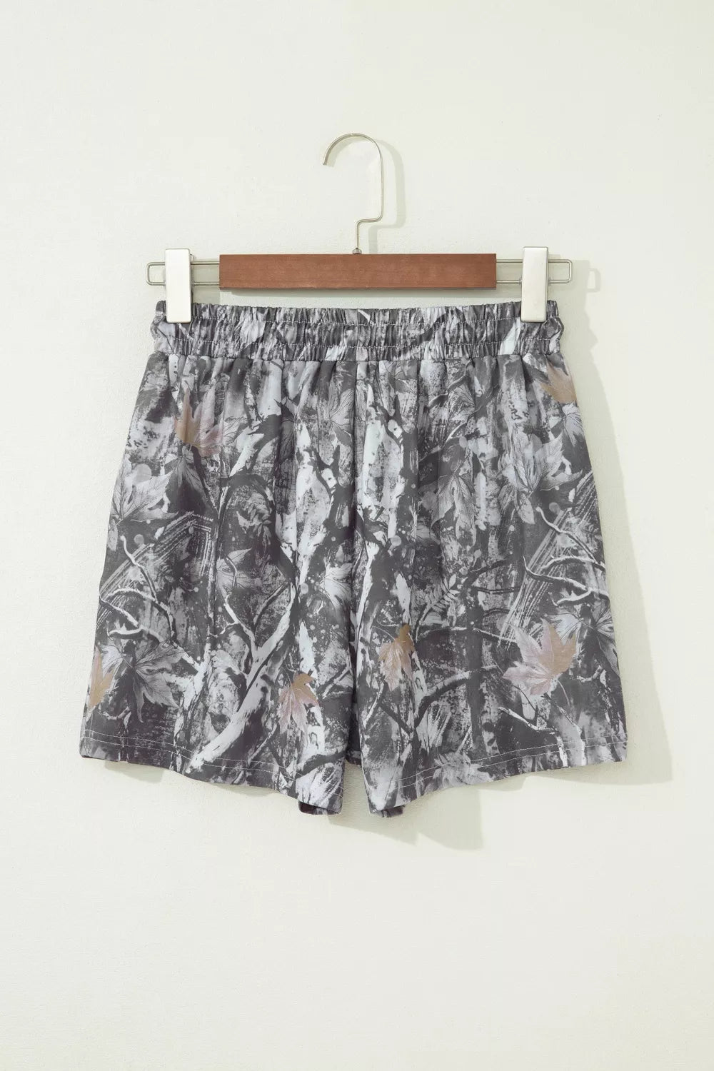 Chino shorts with elastic waist and abstract maple leaf print in grey and beige tones.