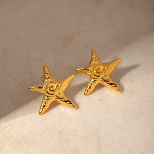 Golden starfish stud earrings with a spiral detail, perfect for beach casual style.