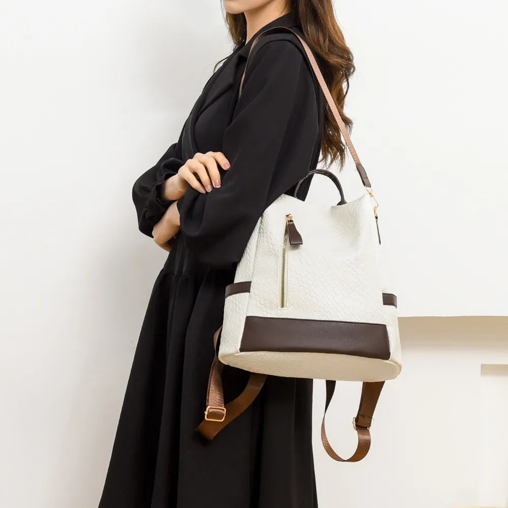 Woven faux leather convertible backpack in ivory with brown trim and adjustable straps.
