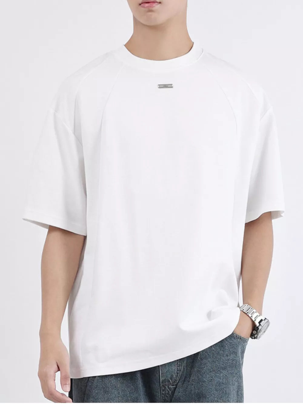 Men's white cotton t-shirt with round neck and subtle chest detail.