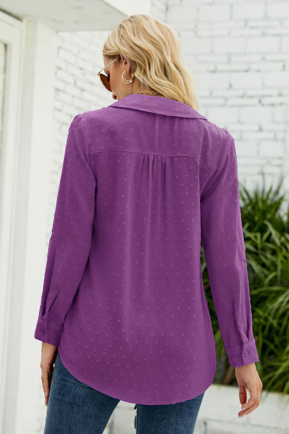 Purple textured collared blouse with button cuffs and a curved hem.