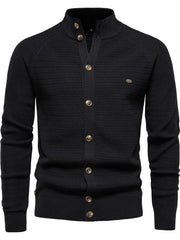 Black textured knit stand collar cardigan with button closure and raglan sleeves.