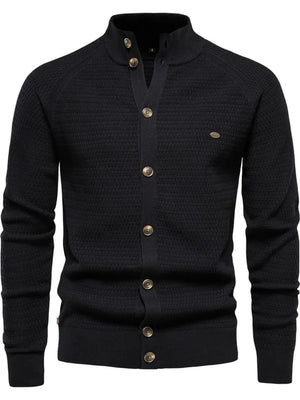 Black textured knit stand collar cardigan with button closure and raglan sleeves.