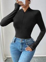 Black zip-neck long sleeve bodysuit with thumbhole cuffs styled with blue jeans