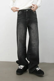 Dark wash distressed denim jeans with a wide-leg silhouette and cat's whisker detailing.