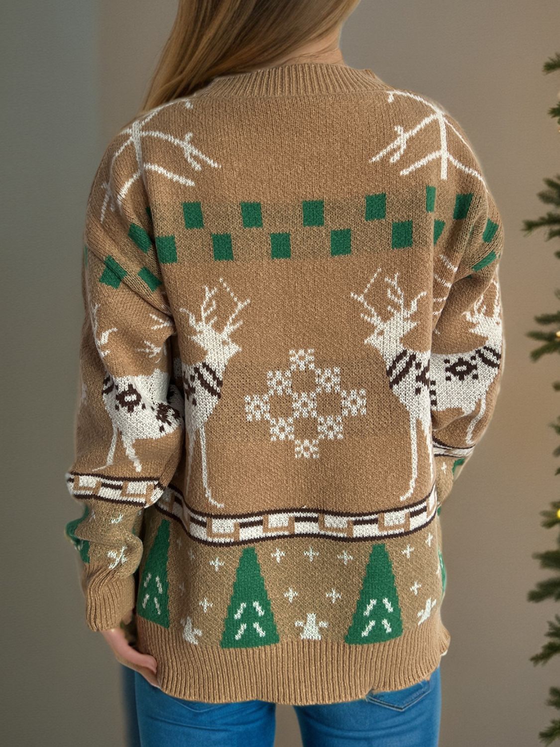 Tan acrylic knit sweater with reindeer, snowflake, and Christmas tree motifs.