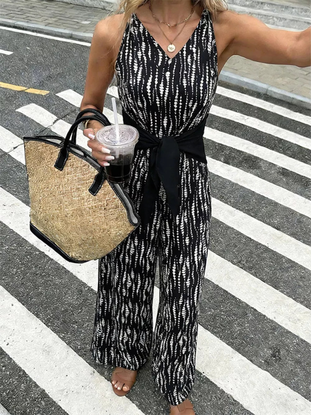 Black abstract print wide-leg jumpsuit with tie waist and V-neck