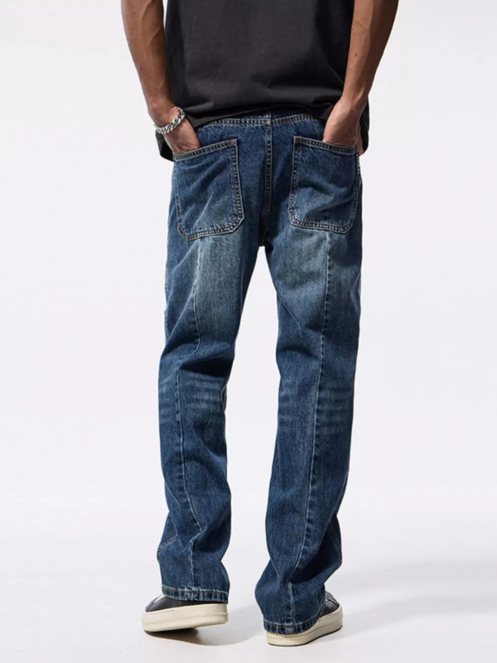 Relaxed fit blue denim jeans with patchwork details and distressed wash.