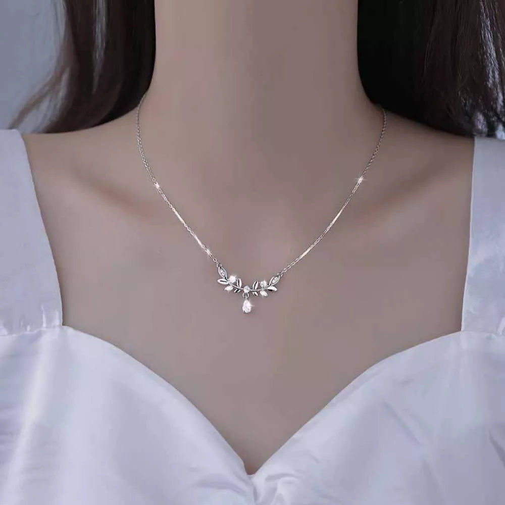 Silver zircon flower pendant necklace with delicate leaf design and teardrop gem.