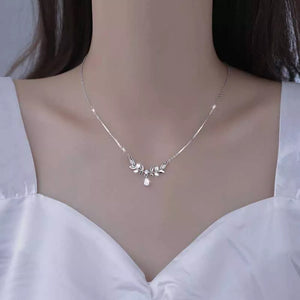 Silver zircon flower pendant necklace with delicate leaf design and teardrop gem.
