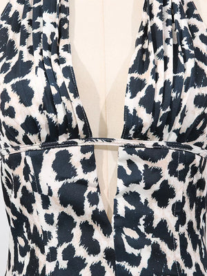 Halter neck leopard print mini dress with deep V-neck cutout detail.