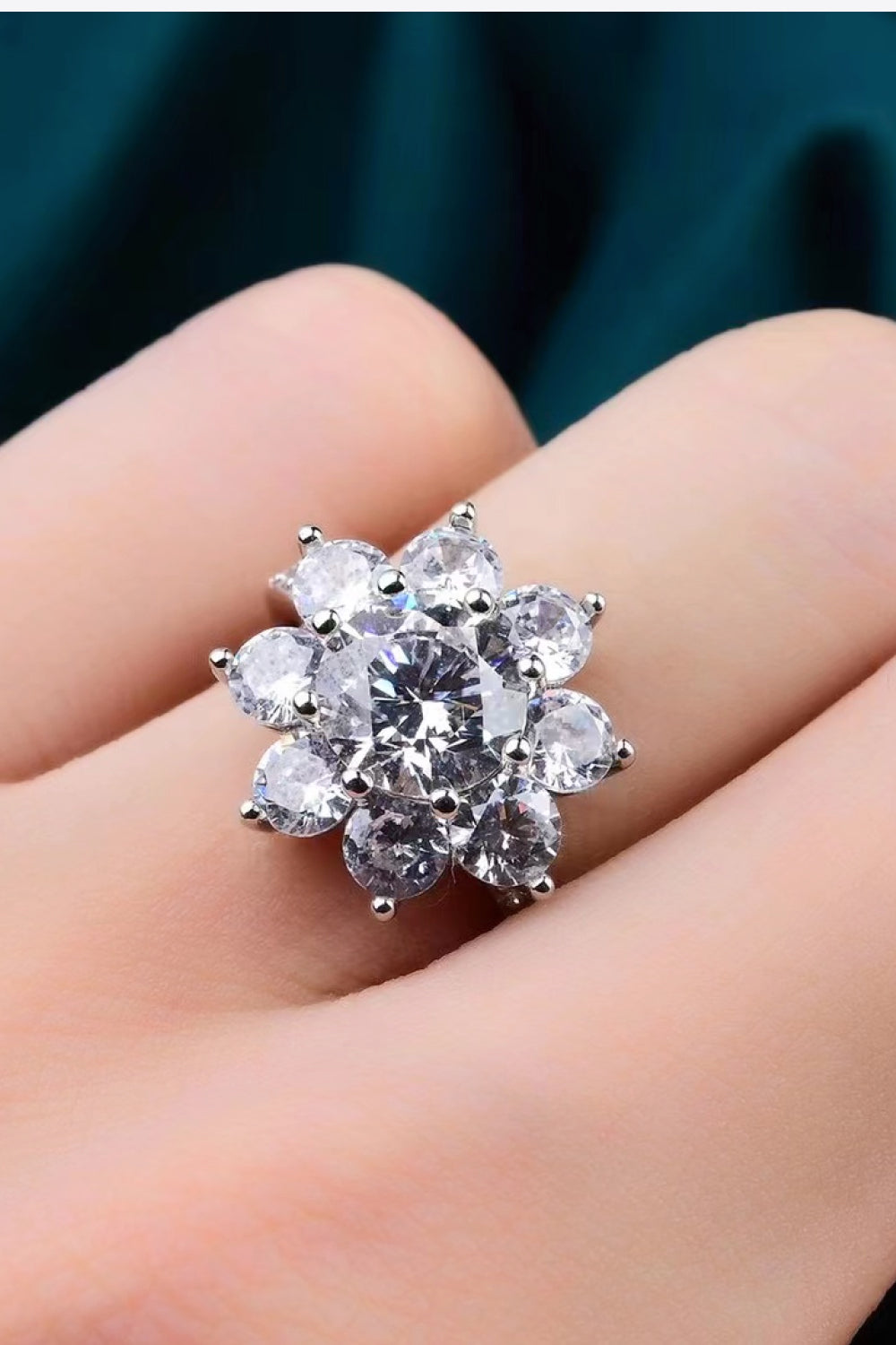 Silver moissanite engagement ring with a flower cluster of round-cut stones.