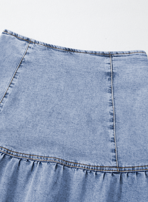 Medium wash denim mini skirt with asymmetrical ruffle hem detail