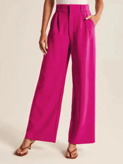 Magenta pleated palazzo trousers with a high waist and wide leg, styled with a white top.