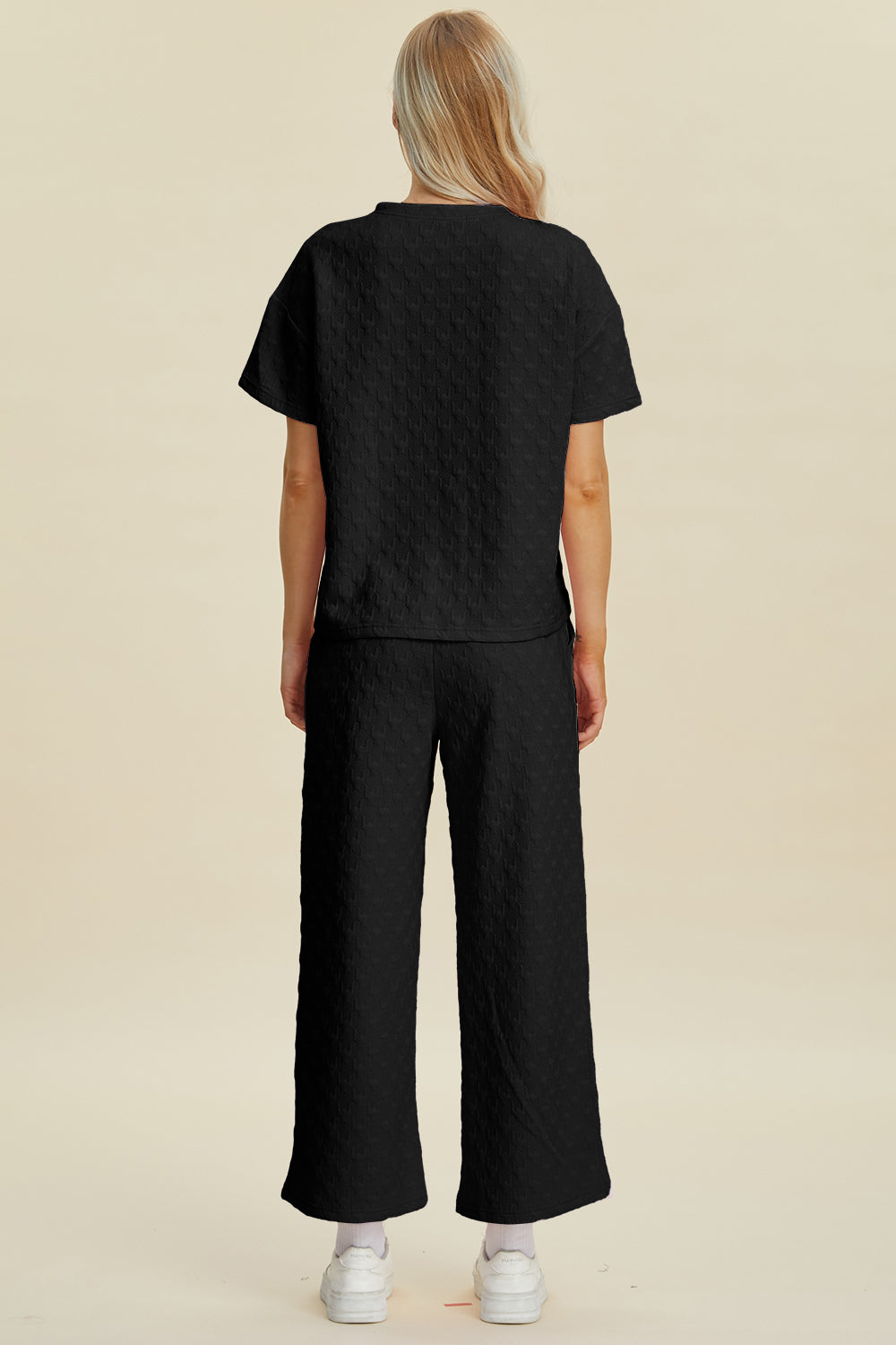 Black textured knit lounge set with wide leg pants and short sleeve top.