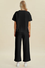 Black textured knit lounge set with wide leg pants and short sleeve top.