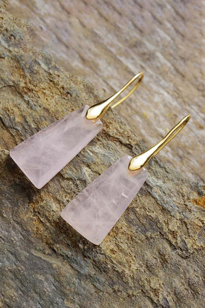 Pink trapezoid drop earrings with gold hooks on textured stone.