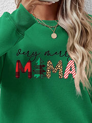 Green long sleeve sweater with abstract Christmas graphic print and text.