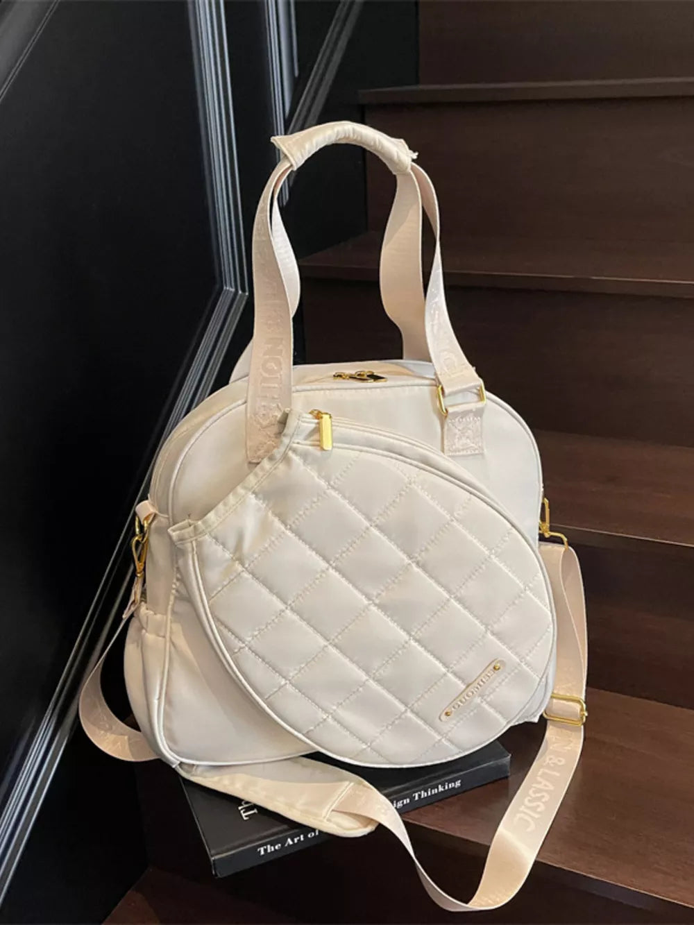 Off-white quilted Oxford bag with adjustable strap and gold hardware.