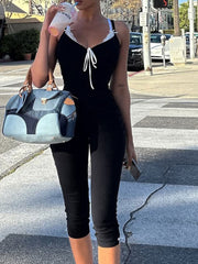 Black lace trim tie-front capri romper with white lace trim and bow detail.