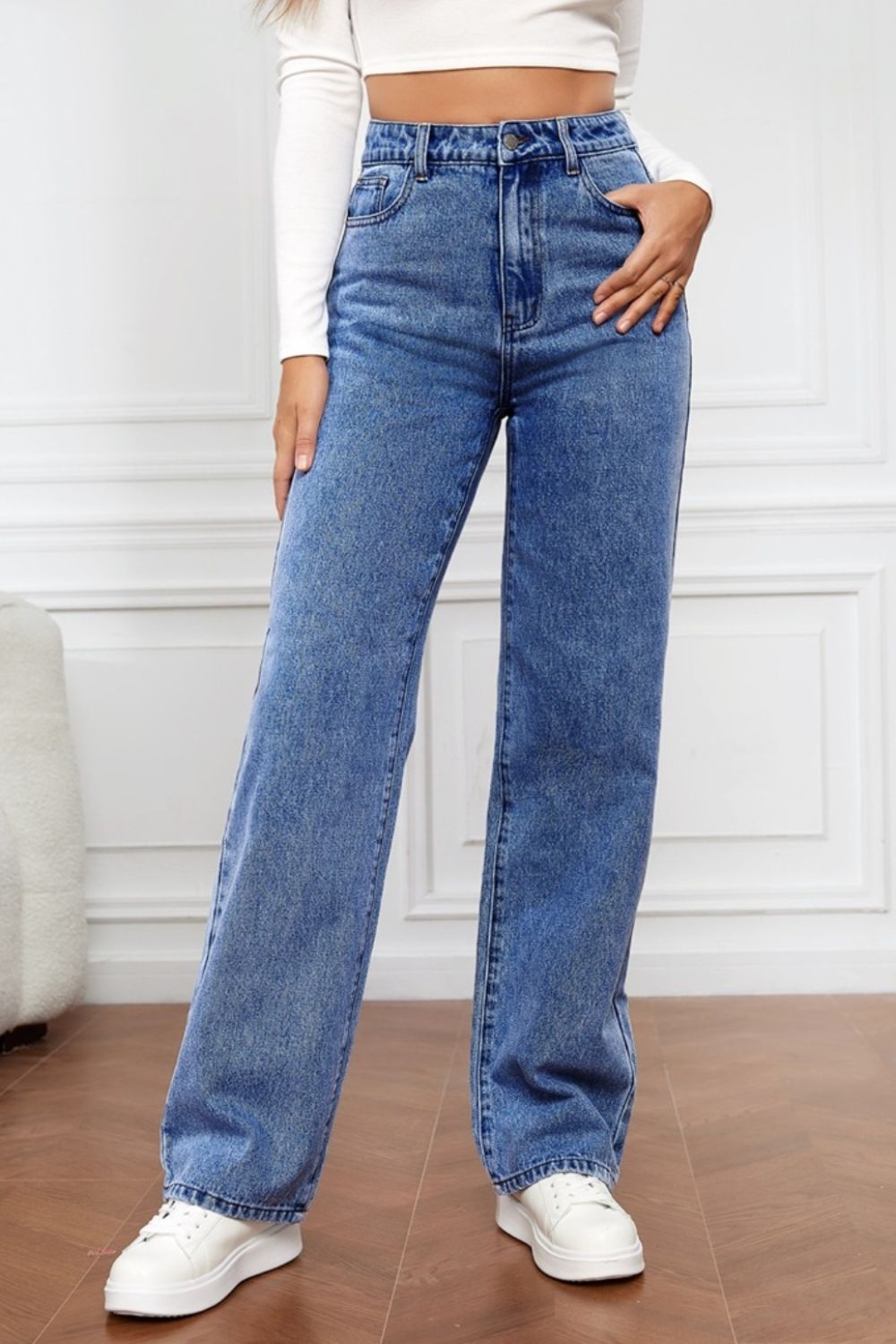 Light blue denim jeans with a wide leg and sculpted waist, buttoned closure.