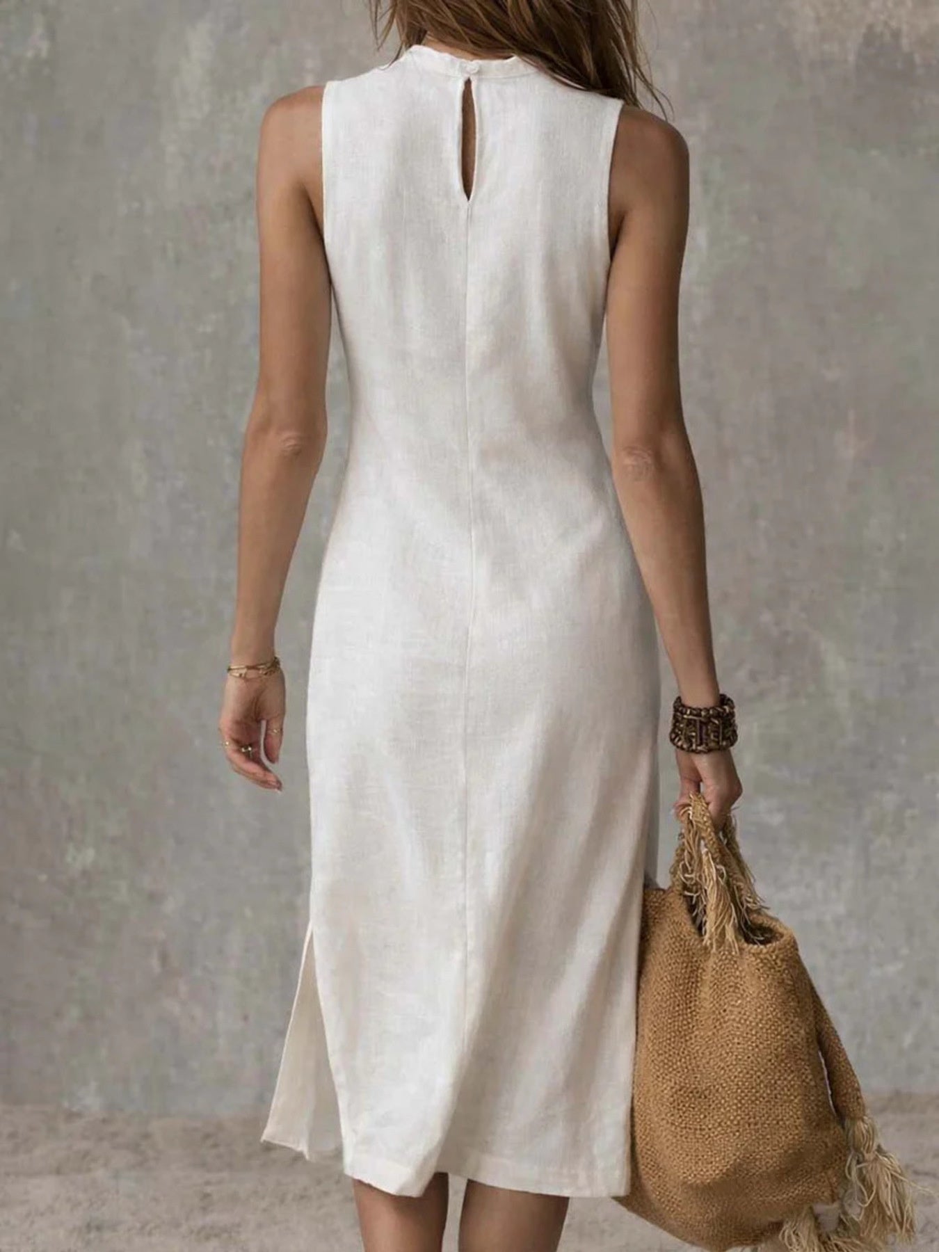 White sleeveless midi dress with buttoned back keyhole and side slit.