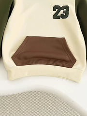 Color block baby hoodie with brown pocket and green 23 graphic.