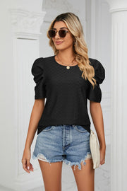 Black perforated sleeve volume top with textured fabric and round neckline.