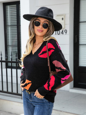 Black v-neck knit pullover with colorful kiss print, acrylic material, casual style.