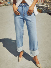 Light wash denim jeans with wide legs and cuffed hems.
