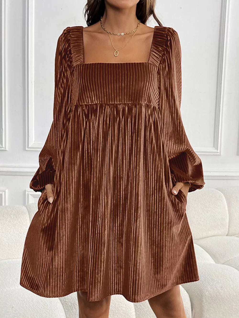 Brown velvet mini dress with square neckline, long sleeves, and pockets.