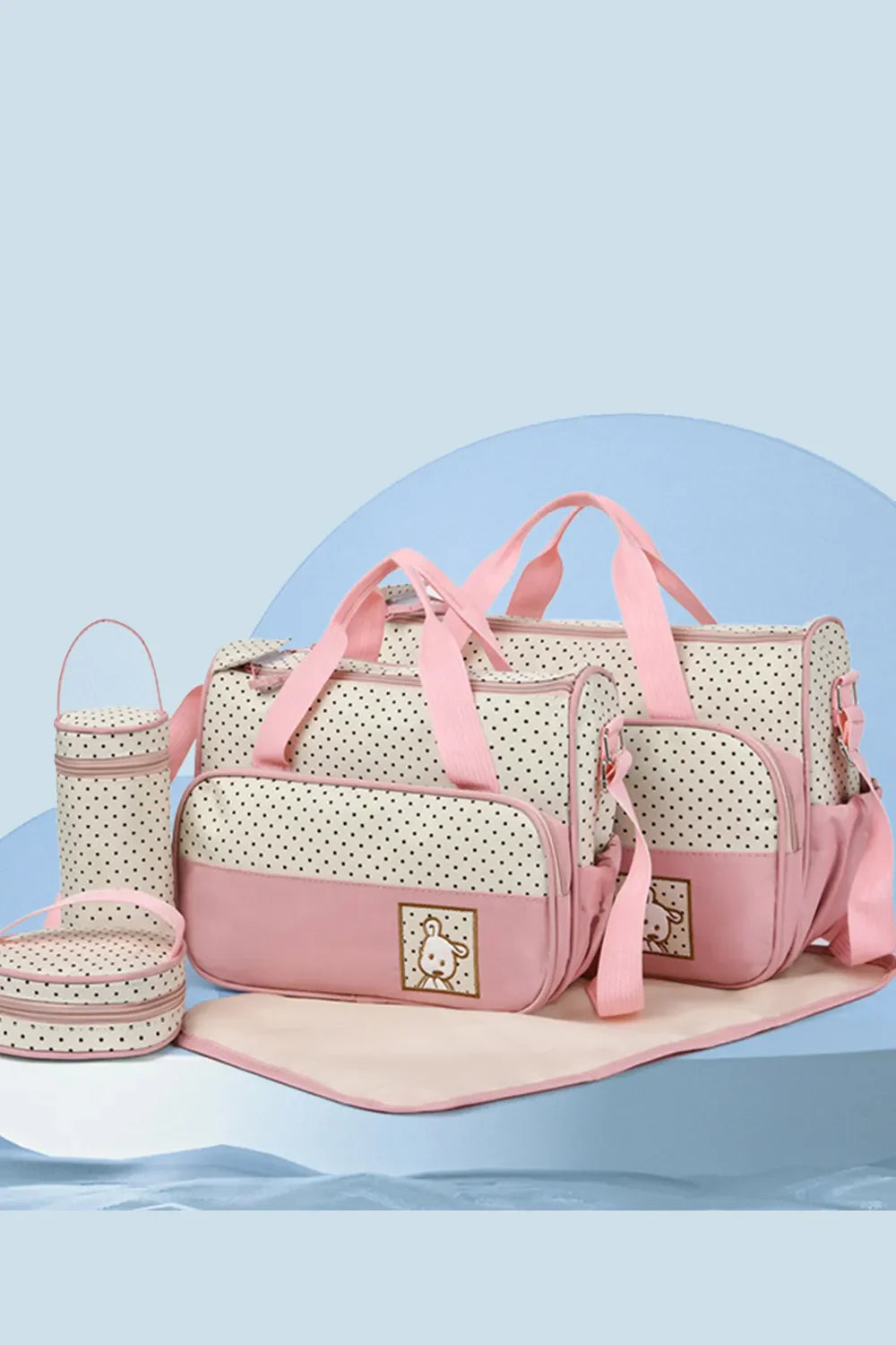 Pink polka dot diaper bag set with matching accessories and embroidered bunny detail.