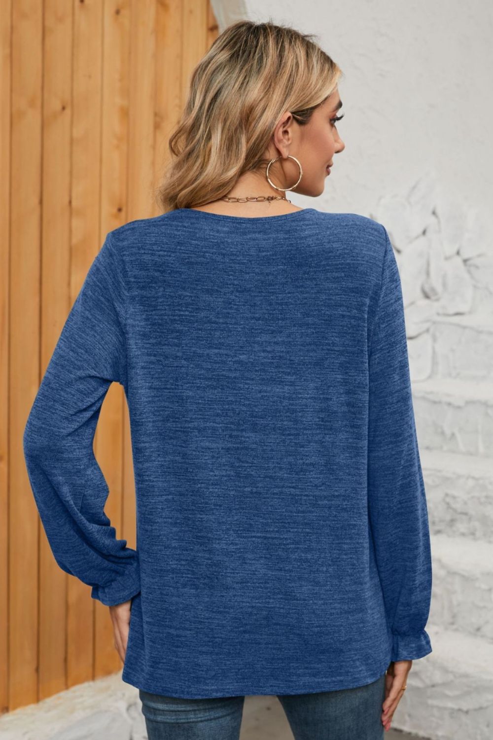Light blue knit top with ruffled cuffs and long sleeves.
