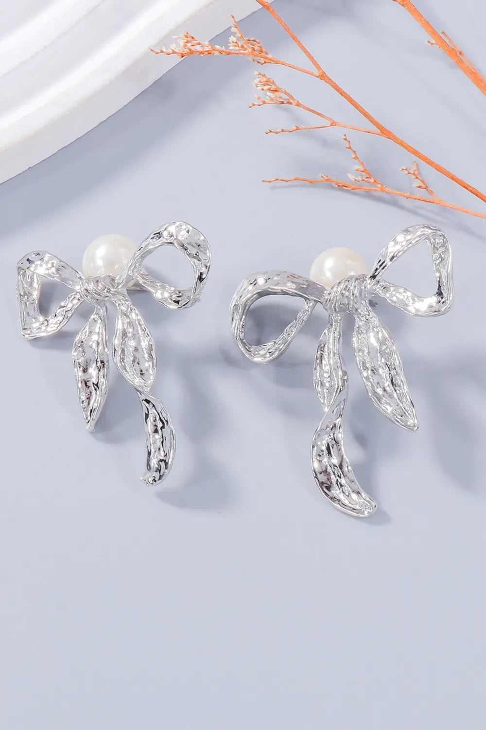 Silver textured bow earrings with pearl accents