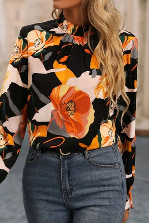 Black high-neck blouse with a bold floral print and long sleeves.