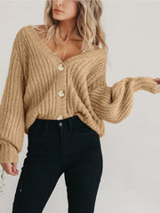 Camel knit cardigan with voluminous sleeves and button front, styled with black jeans.