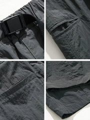 Dark gray technical fabric cargo pants with belt detail, cargo pockets, and stitching.