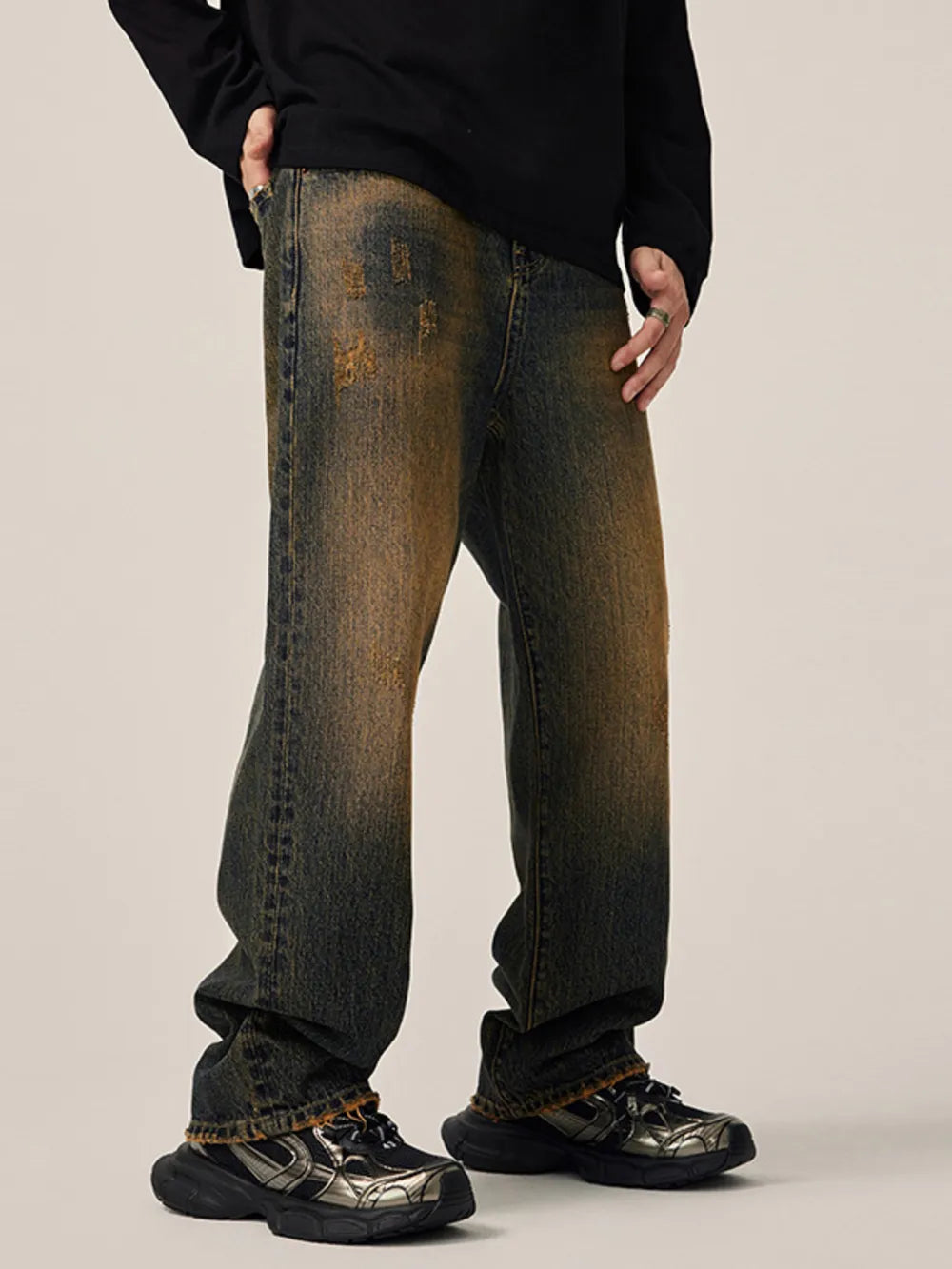 Men's relaxed fit jeans in vintage wash denim with distressed details.
