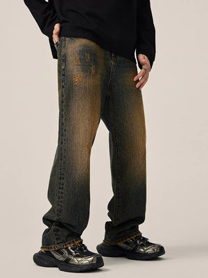 Men's relaxed fit jeans in vintage wash denim with distressed details.
